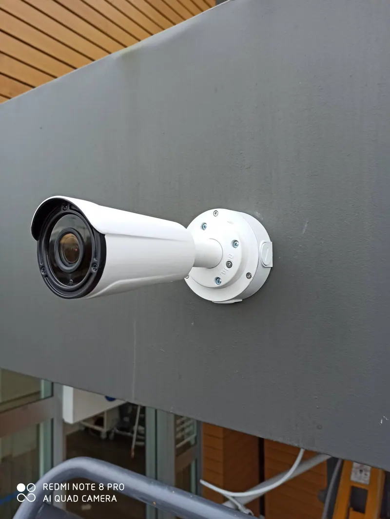 Une caméra de vidéosurveillance posée par HOME SECURITY sur la façade d’un magasin