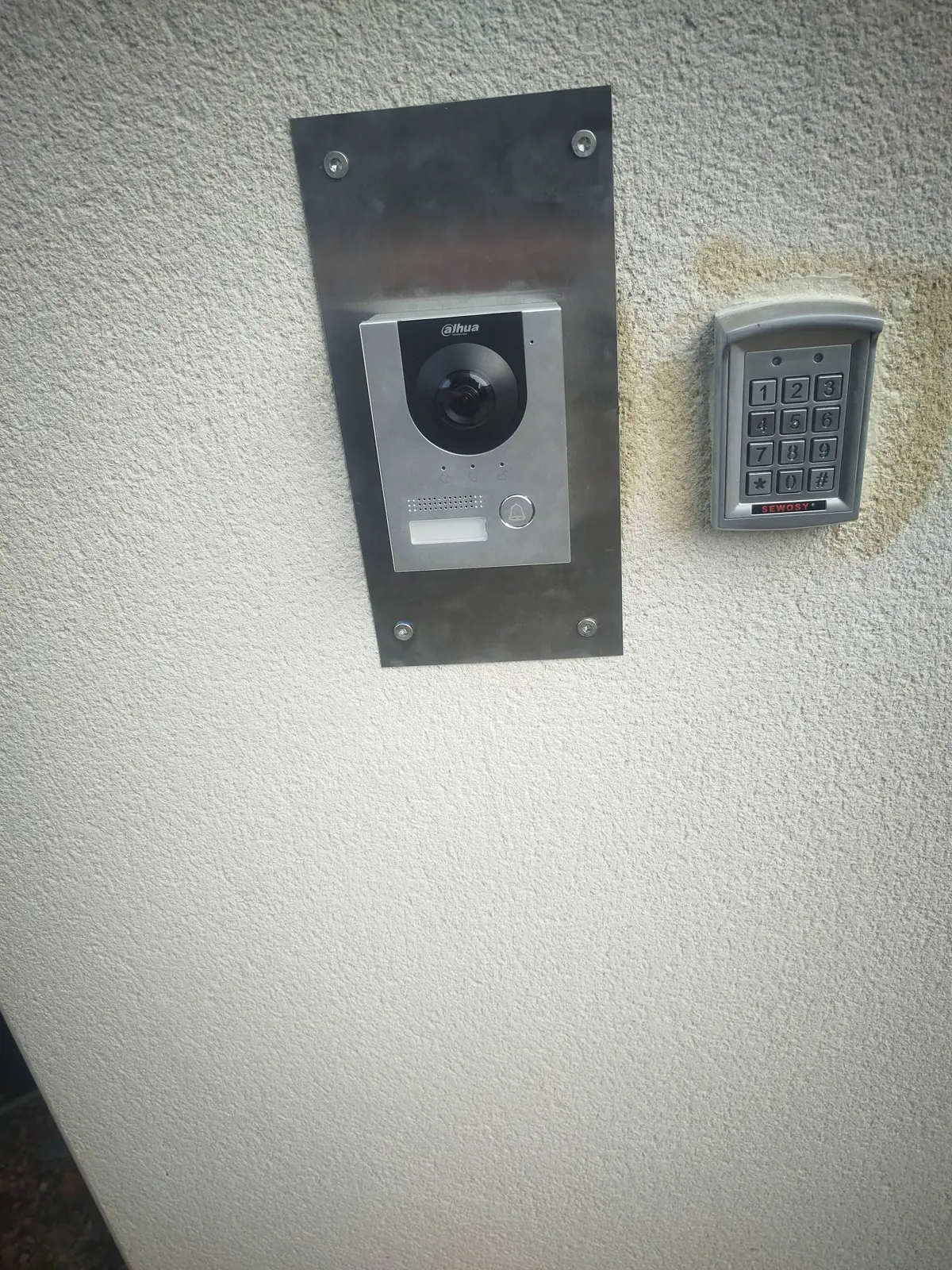 Un visiophone connecté et son digicode posés à l’entrée d’une propriété